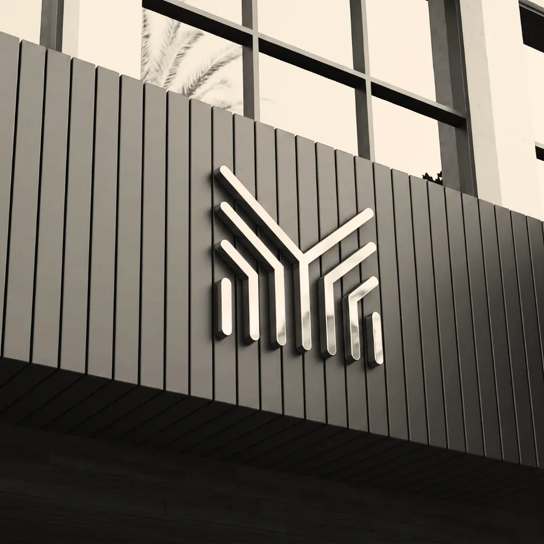 The SMG mark as a brushed-metal sign on a dark slatted facade.